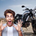 Una moto ferma su superficie sterrata e un ragazzo meravigliato