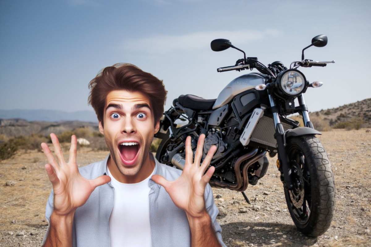 Una moto ferma su superficie sterrata e un ragazzo meravigliato