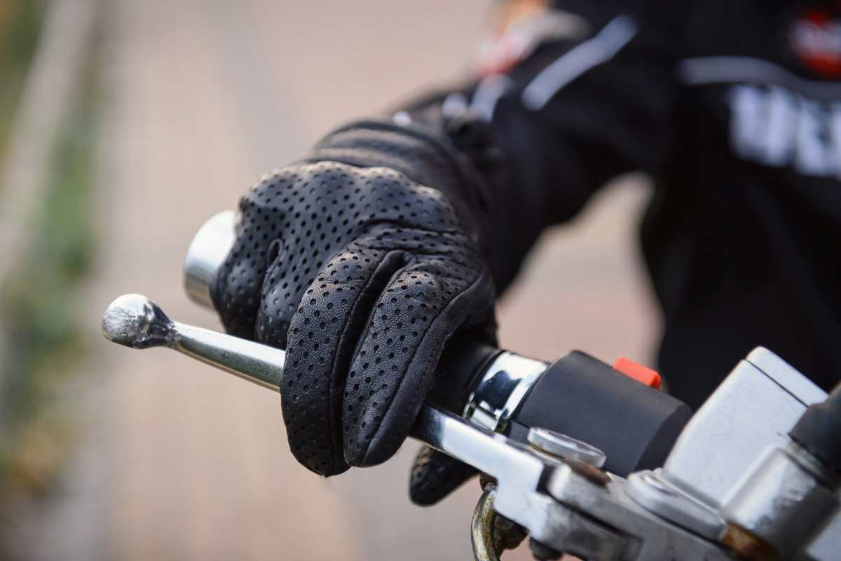 Mano sul manubrio della moto